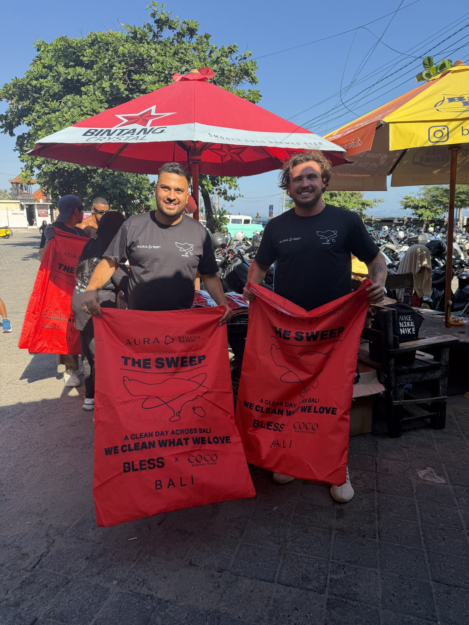 BLESS founders Younes Deaibes and Joshua Rix holding red The Sweep bags in Bali